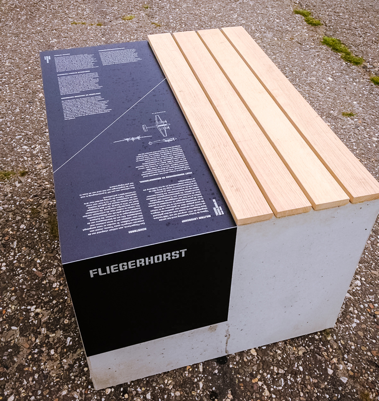 Zitelement met een houten bankje en een informatief bord over de Fliegerhorst