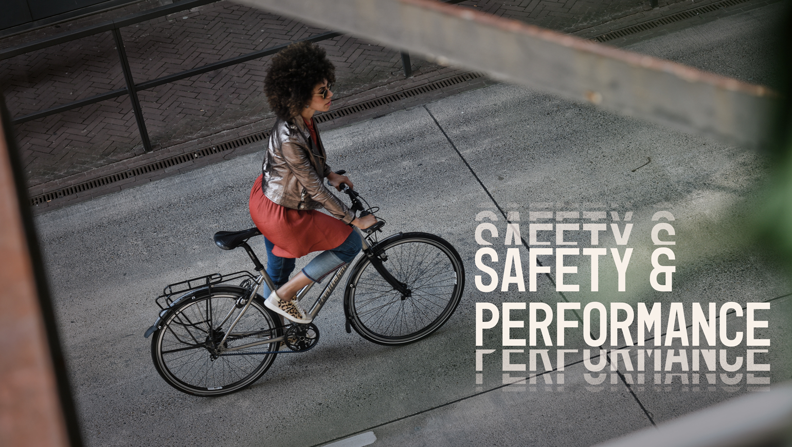 Vrouw fietst door een straat, met de tekst: safety and performance
